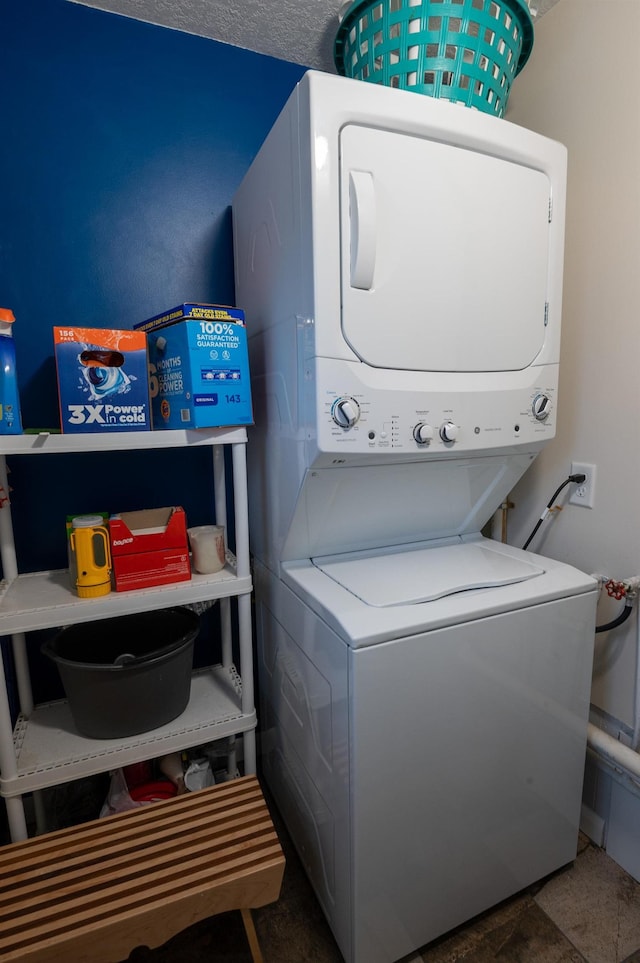 clothes washing area featuring stacked washing maching and dryer and a textured ceiling