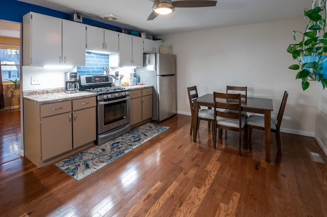 kitchen featuring white cabinets, appliances with stainless steel finishes, ceiling fan, and wood-type flooring