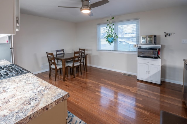 dining room featuring ceiling fan and dark wood-type flooring