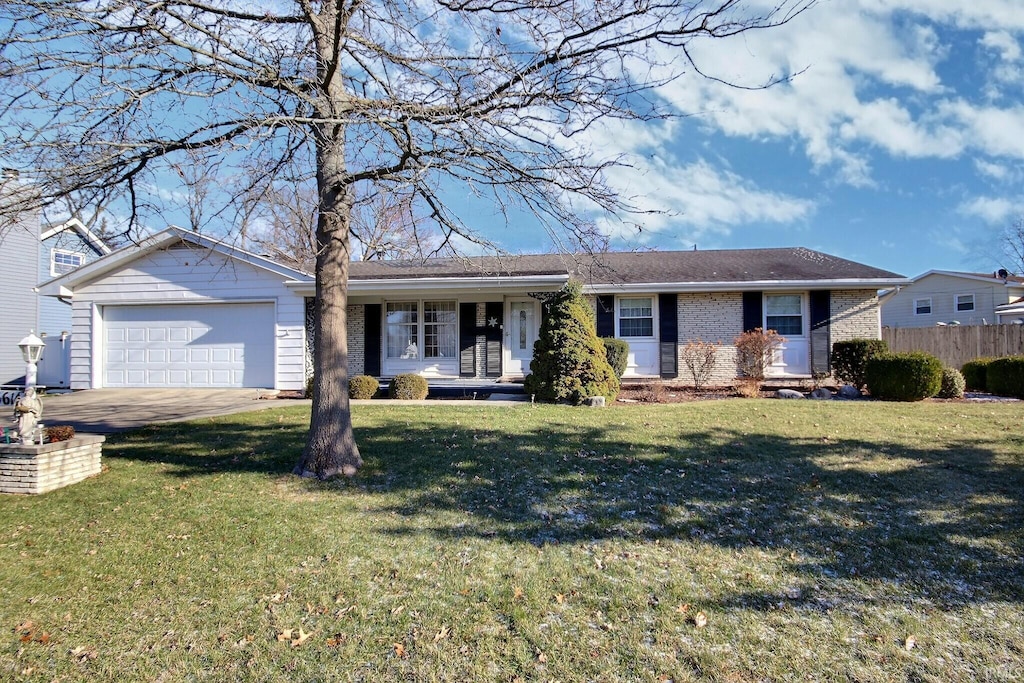 ranch-style house featuring a front yard and a garage