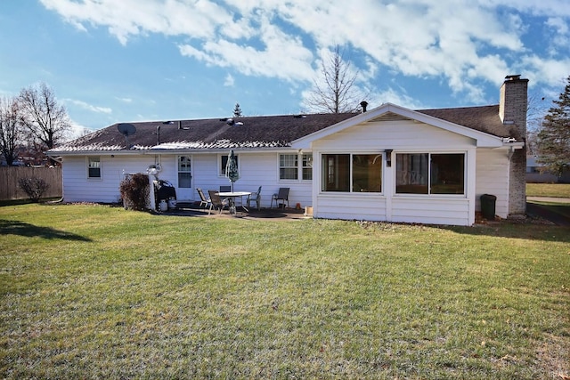 rear view of house featuring a lawn and a patio