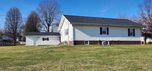 back of property featuring central AC and a yard