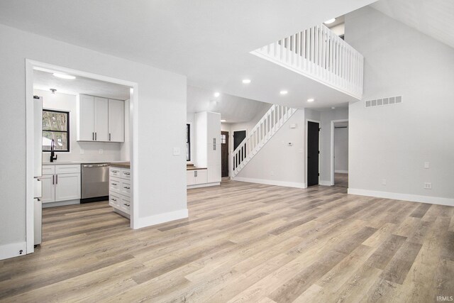 unfurnished living room featuring light hardwood / wood-style flooring and sink