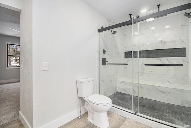 bathroom with hardwood / wood-style floors, toilet, and walk in shower