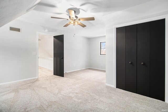 unfurnished bedroom with light colored carpet and ceiling fan