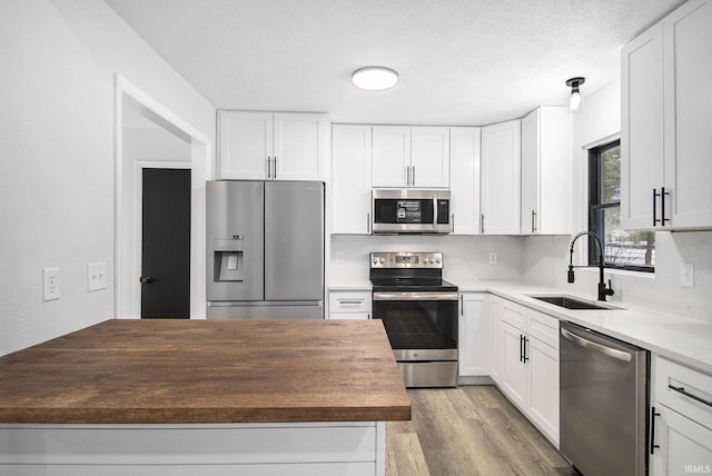 kitchen with sink, white cabinets, and appliances with stainless steel finishes