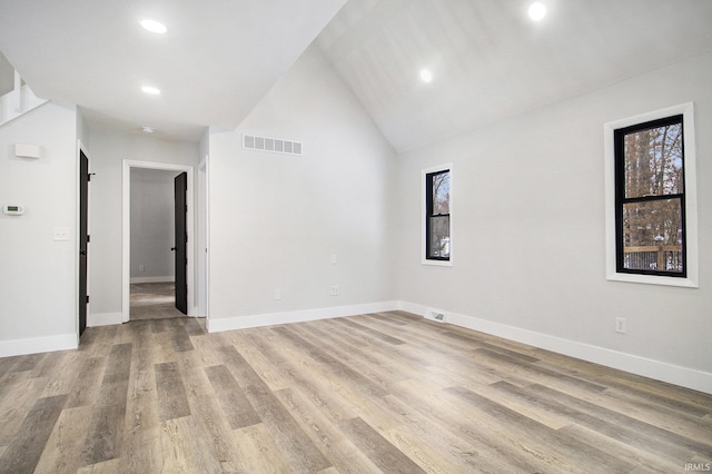 unfurnished room featuring high vaulted ceiling and light wood-type flooring