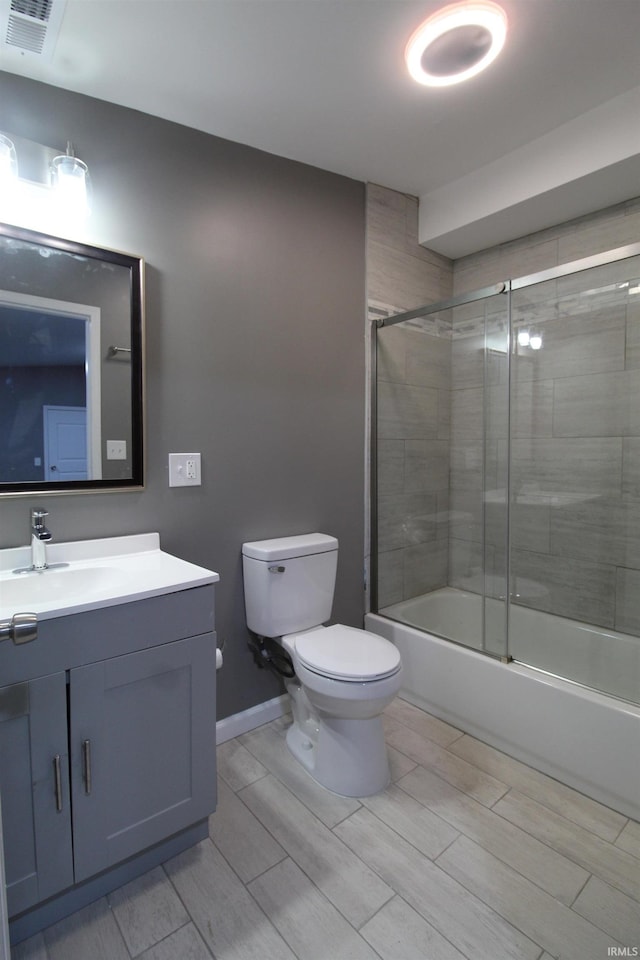 full bathroom with shower / bath combination with glass door, vanity, and toilet