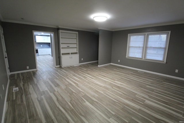 empty room featuring hardwood / wood-style floors and ornamental molding