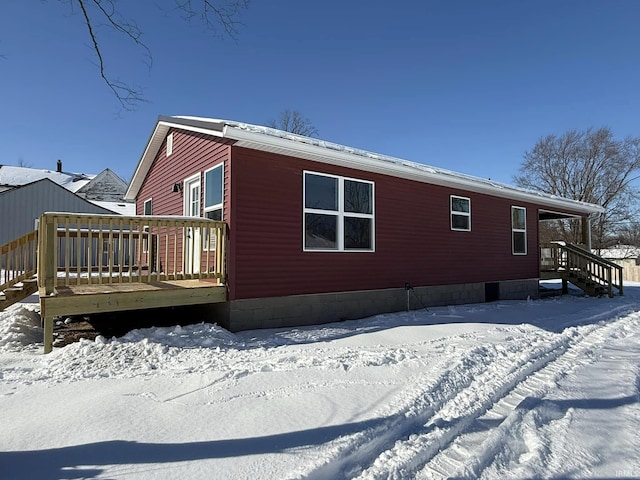 snow covered property with a wooden deck