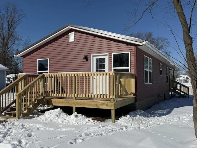 snow covered property featuring a wooden deck