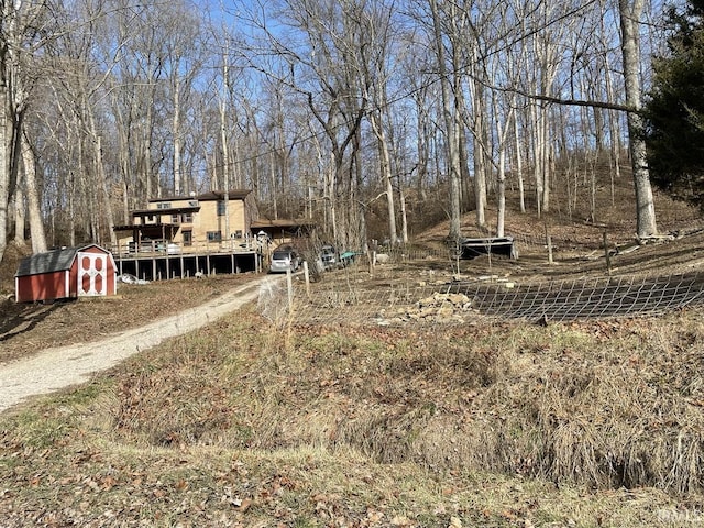 view of yard featuring a storage unit and a wooden deck