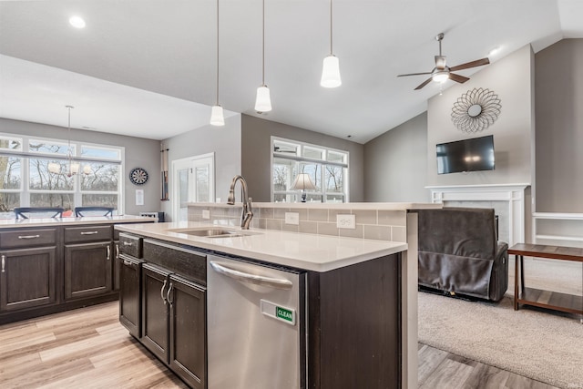 kitchen with dishwasher, light hardwood / wood-style floors, decorative light fixtures, and sink