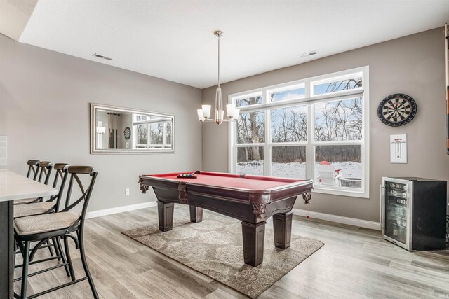 playroom with a chandelier, light hardwood / wood-style flooring, plenty of natural light, and pool table