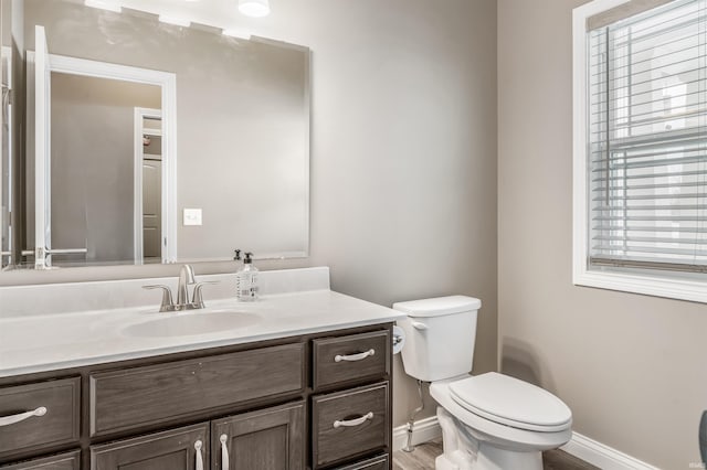 bathroom featuring vanity, toilet, and plenty of natural light