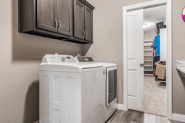 washroom with light hardwood / wood-style floors, cabinets, and independent washer and dryer