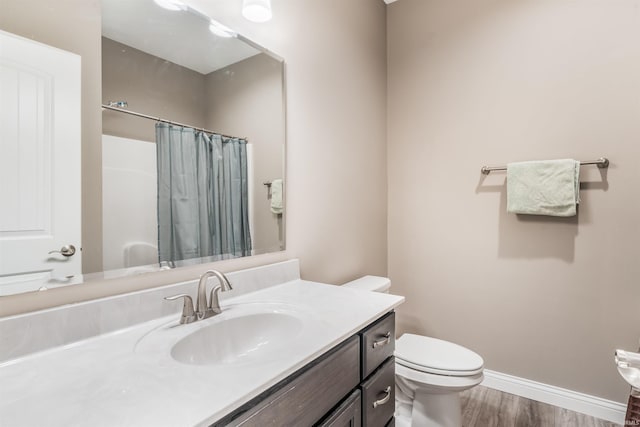 bathroom featuring a shower with curtain, hardwood / wood-style floors, vanity, and toilet