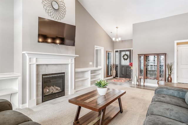 living room featuring a fireplace, high vaulted ceiling, and a notable chandelier