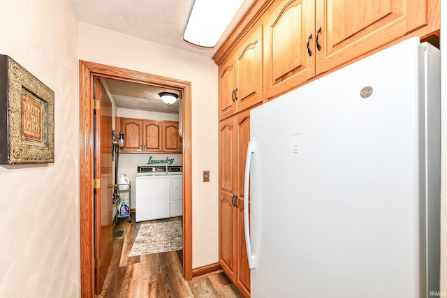 laundry room with washer and clothes dryer, cabinets, a textured ceiling, and hardwood / wood-style flooring