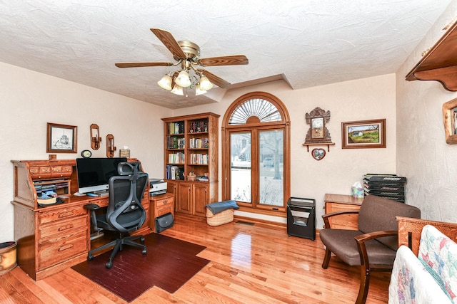 office featuring a textured ceiling, light hardwood / wood-style flooring, and ceiling fan