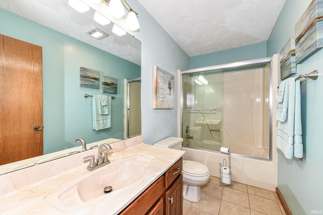 full bathroom with vanity, a textured ceiling, shower / bath combination with glass door, tile patterned flooring, and toilet