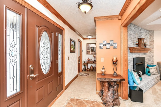 entryway with a textured ceiling, a brick fireplace, crown molding, and light tile patterned flooring