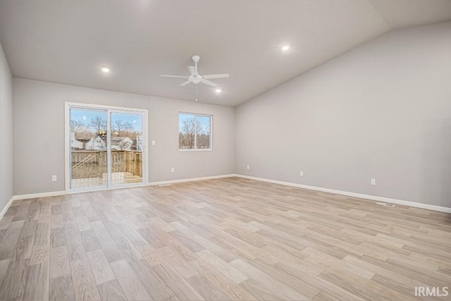 spare room featuring light wood-type flooring, vaulted ceiling, and ceiling fan