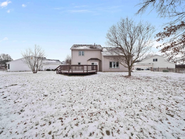 snow covered house with a wooden deck