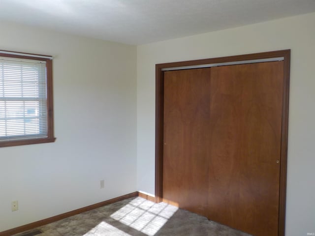 unfurnished bedroom featuring light carpet and a closet