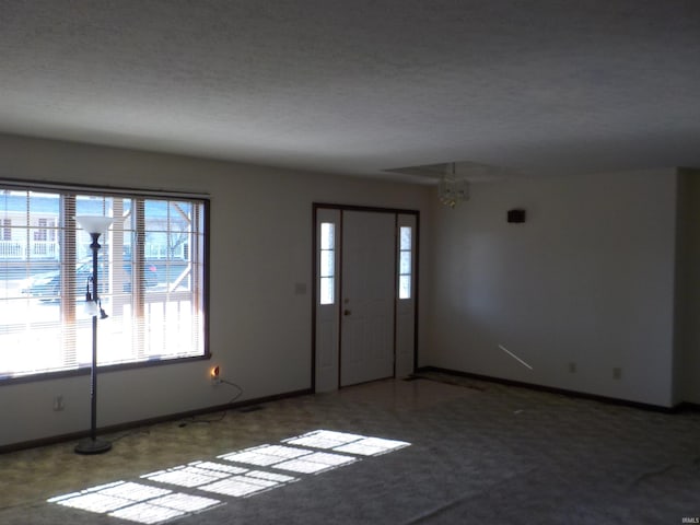 foyer with carpet and a notable chandelier