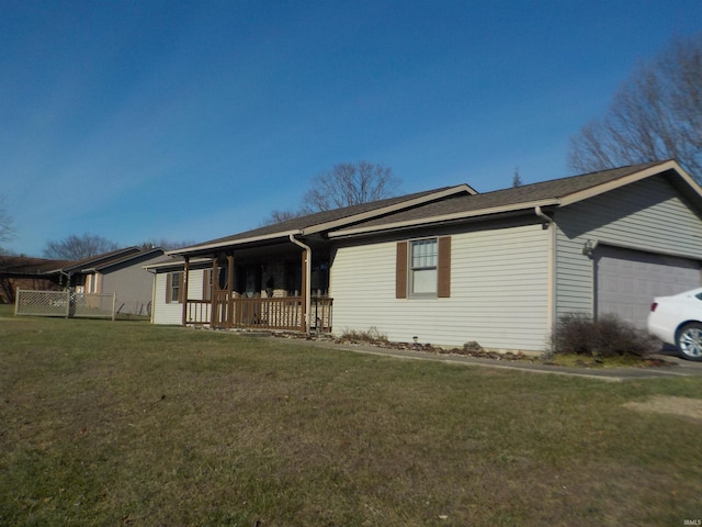 ranch-style home featuring covered porch, a garage, and a front yard