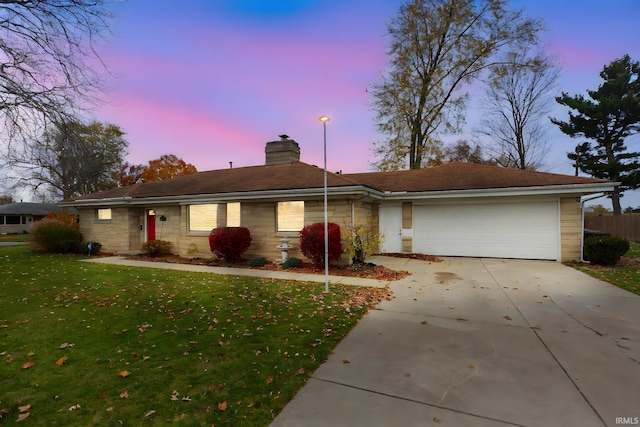 ranch-style house featuring a yard and a garage