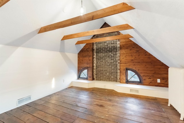 additional living space with vaulted ceiling with beams, hardwood / wood-style floors, and radiator