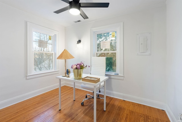 office with hardwood / wood-style flooring, plenty of natural light, ceiling fan, and ornamental molding