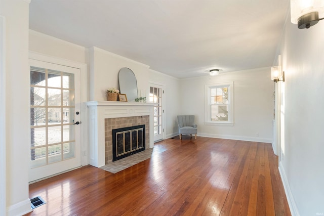 unfurnished living room with a fireplace, hardwood / wood-style flooring, and a wealth of natural light