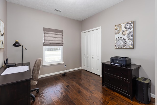 office area with dark wood-type flooring and a textured ceiling