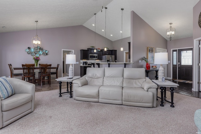 living room with light carpet, high vaulted ceiling, and an inviting chandelier