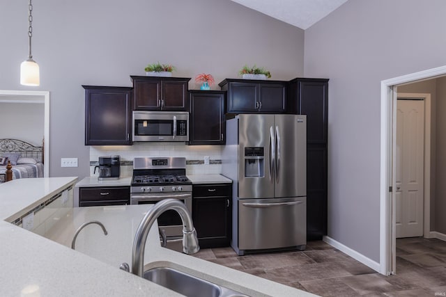 kitchen featuring decorative light fixtures, backsplash, stainless steel appliances, and vaulted ceiling