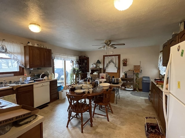 kitchen featuring a textured ceiling, ceiling fan, white appliances, and sink