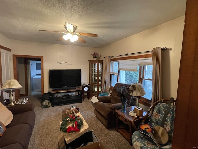 living room featuring carpet flooring, a textured ceiling, washer / clothes dryer, and ceiling fan