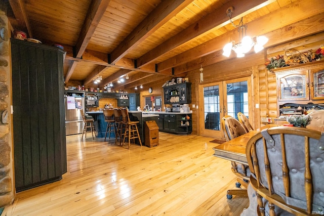 dining room with rustic walls, beamed ceiling, a chandelier, light hardwood / wood-style floors, and wood ceiling