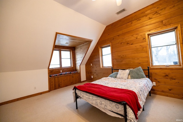 carpeted bedroom with wood walls and vaulted ceiling