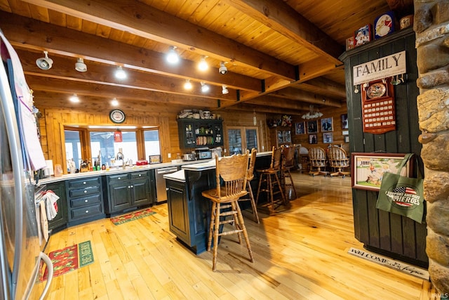 bar featuring appliances with stainless steel finishes, light wood-type flooring, wooden ceiling, beamed ceiling, and wood walls