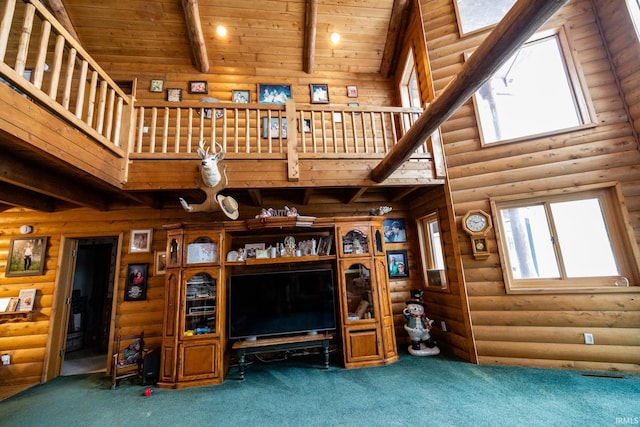 unfurnished living room featuring beam ceiling, high vaulted ceiling, and rustic walls