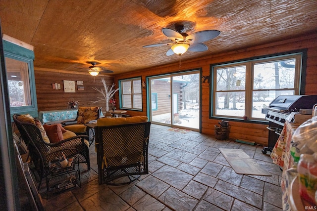 sunroom / solarium with a healthy amount of sunlight, ceiling fan, and wooden ceiling