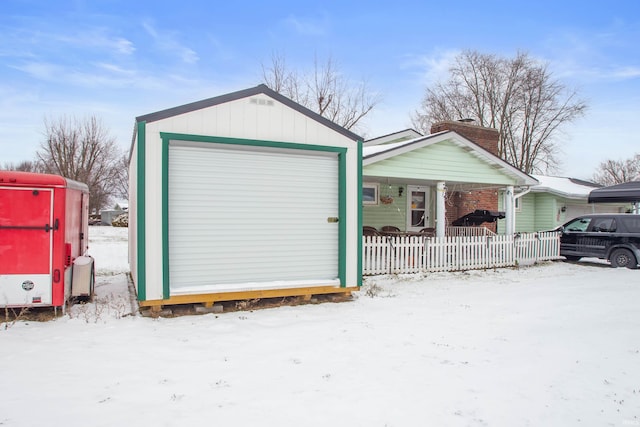 view of front facade featuring covered porch, a garage, and an outdoor structure