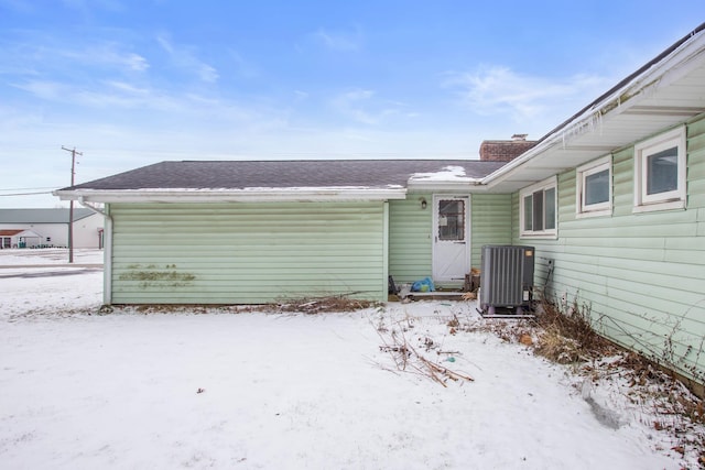 snow covered property with central AC unit