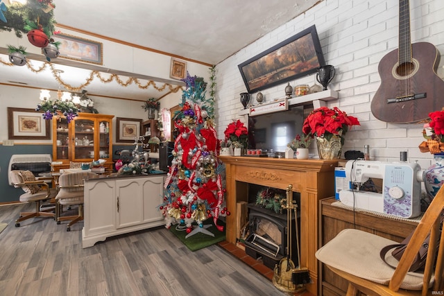 kitchen featuring dark hardwood / wood-style floors, white cabinetry, and brick wall