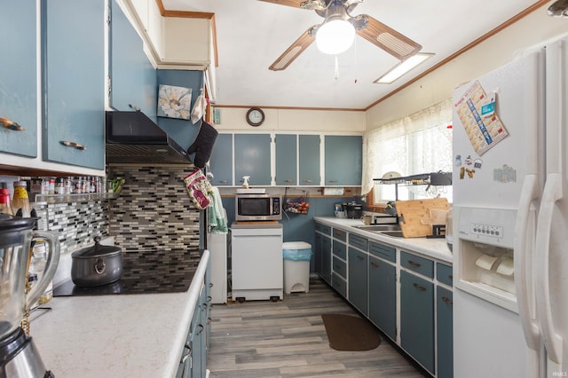 kitchen with dark hardwood / wood-style flooring, white refrigerator with ice dispenser, and blue cabinets