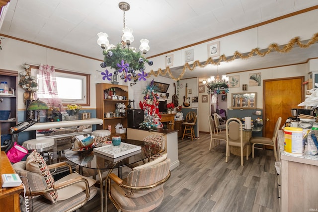 dining area with hardwood / wood-style flooring, a notable chandelier, and crown molding